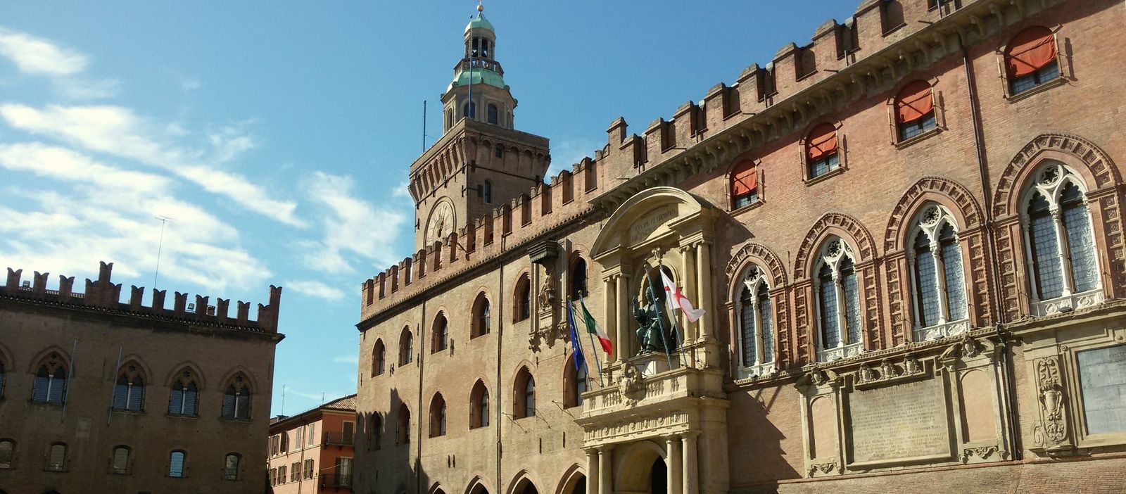 Palazzo d’Accursio, Bologna’s city hall on Piazza Maggiore, with its clock tower and crenellated brick walls.